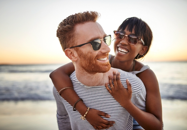 man and woman having piggy back on the beach