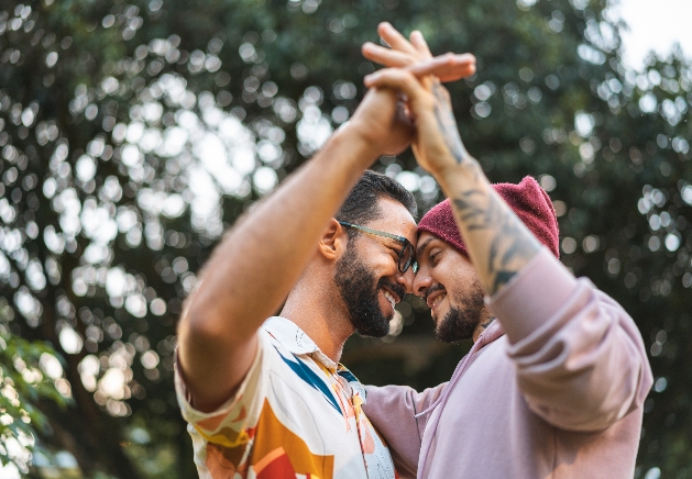 two men holding hands dancing outside