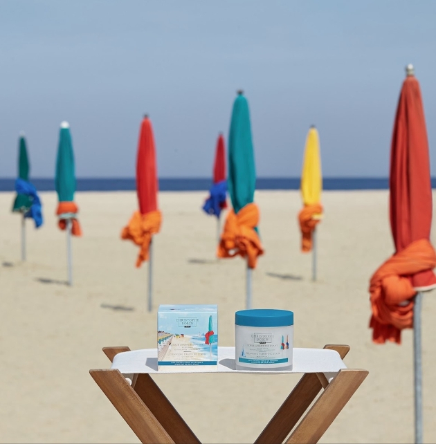 Containers on a wooden table on the beach with flags. 