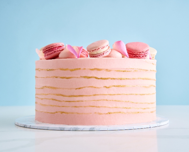 Single tier Lola's Cupcake's wedding cake topped with pink macarons