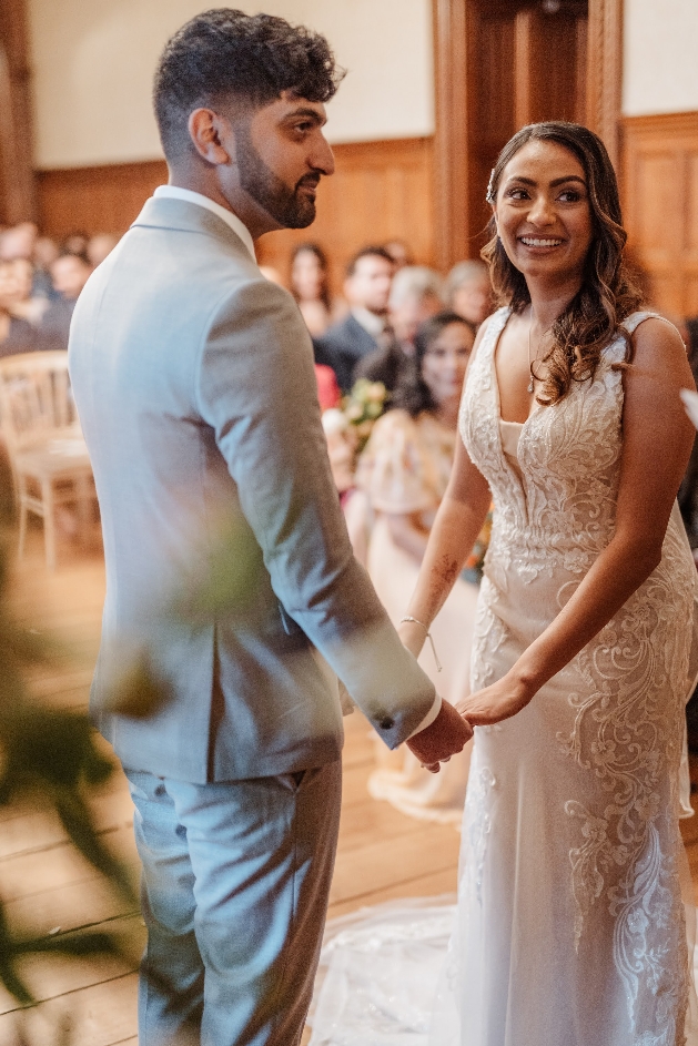 couple holding hands and saying wedding vows in wedding attire