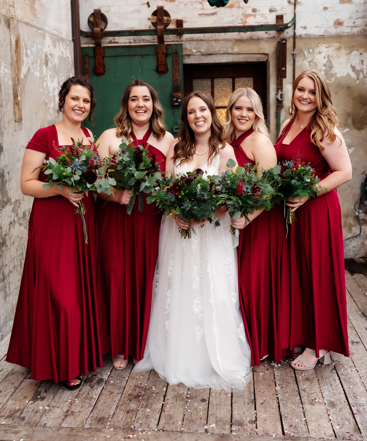 bride and bridesmaids in red winter wedding holding bouquets