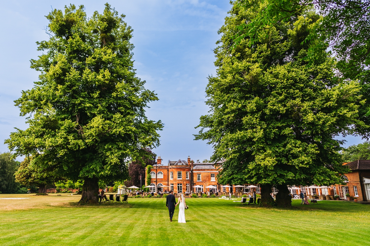 historic red brick building, curves in structure, grass field out front