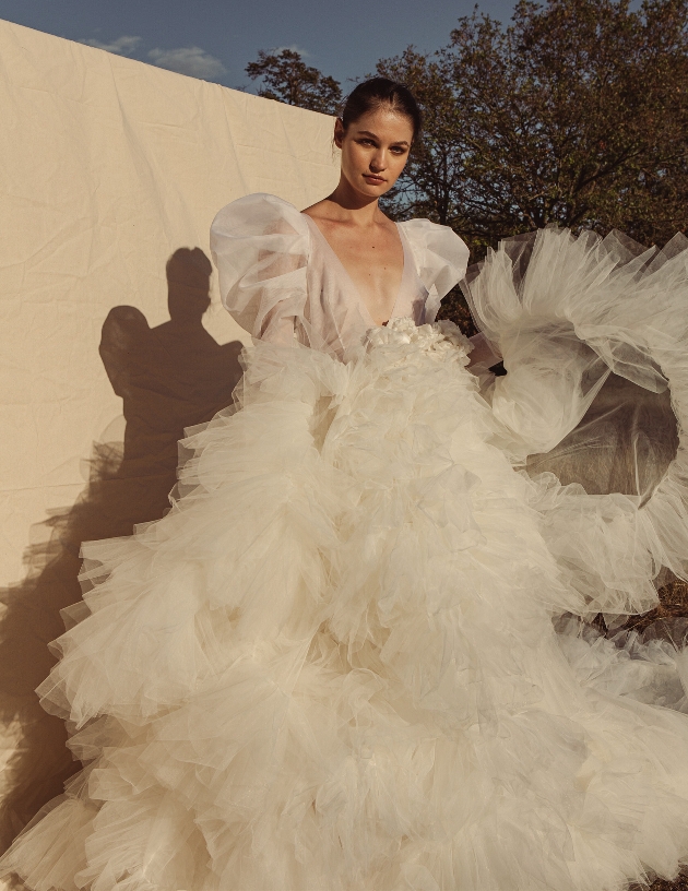 model in dress with large layered frill skirt and large volume sleeves