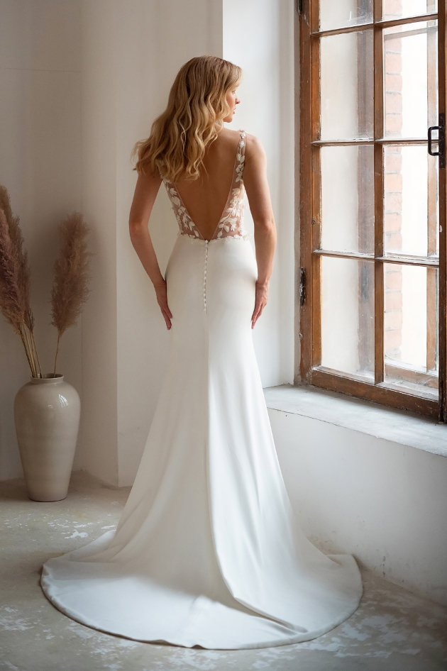 model in fishtail white dress with deep v back sheer and lace details 