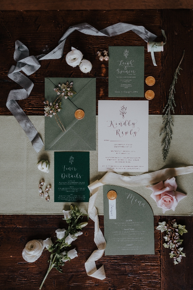 green stationery suite on display on wooden table