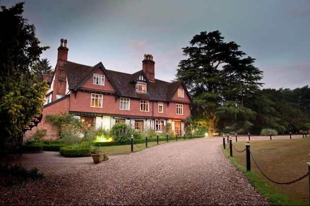 manor house with gravel drive tress in background