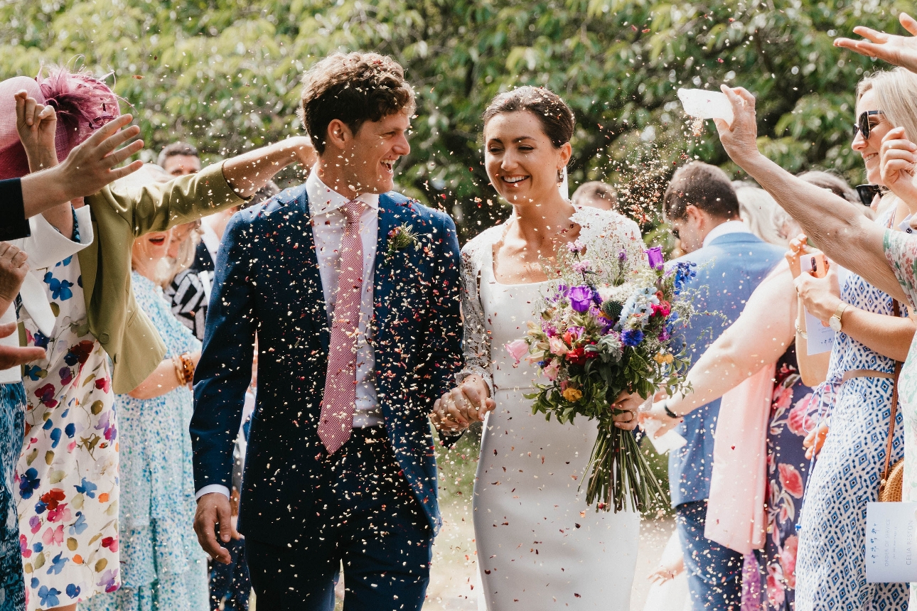 bride and groom outside being showered in confetti