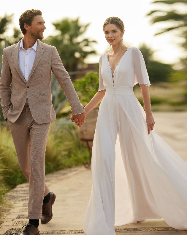 model in white jumpsuit, loose flowing fabric, deep neckline