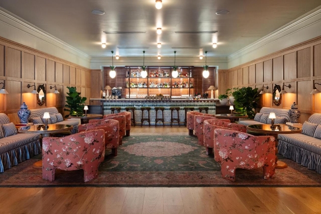 A bar with pink chairs and sofas