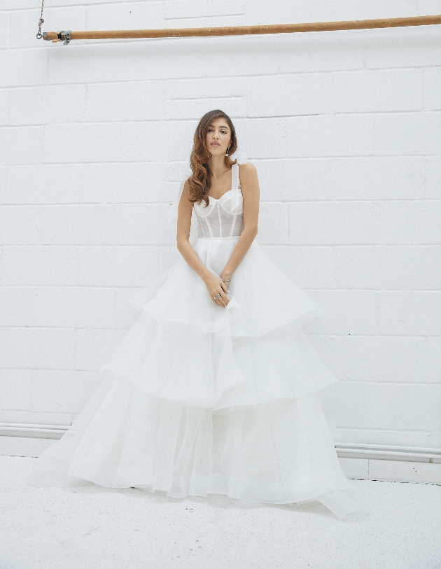 model in corset top see-through panel bows on shoulders, three tiered skirt