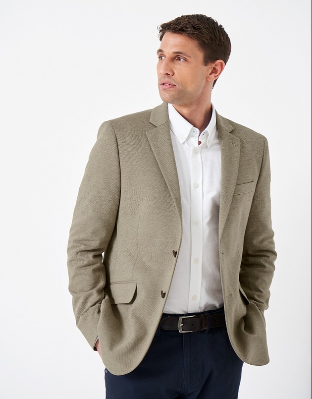 A man in a white shirt and green blazer