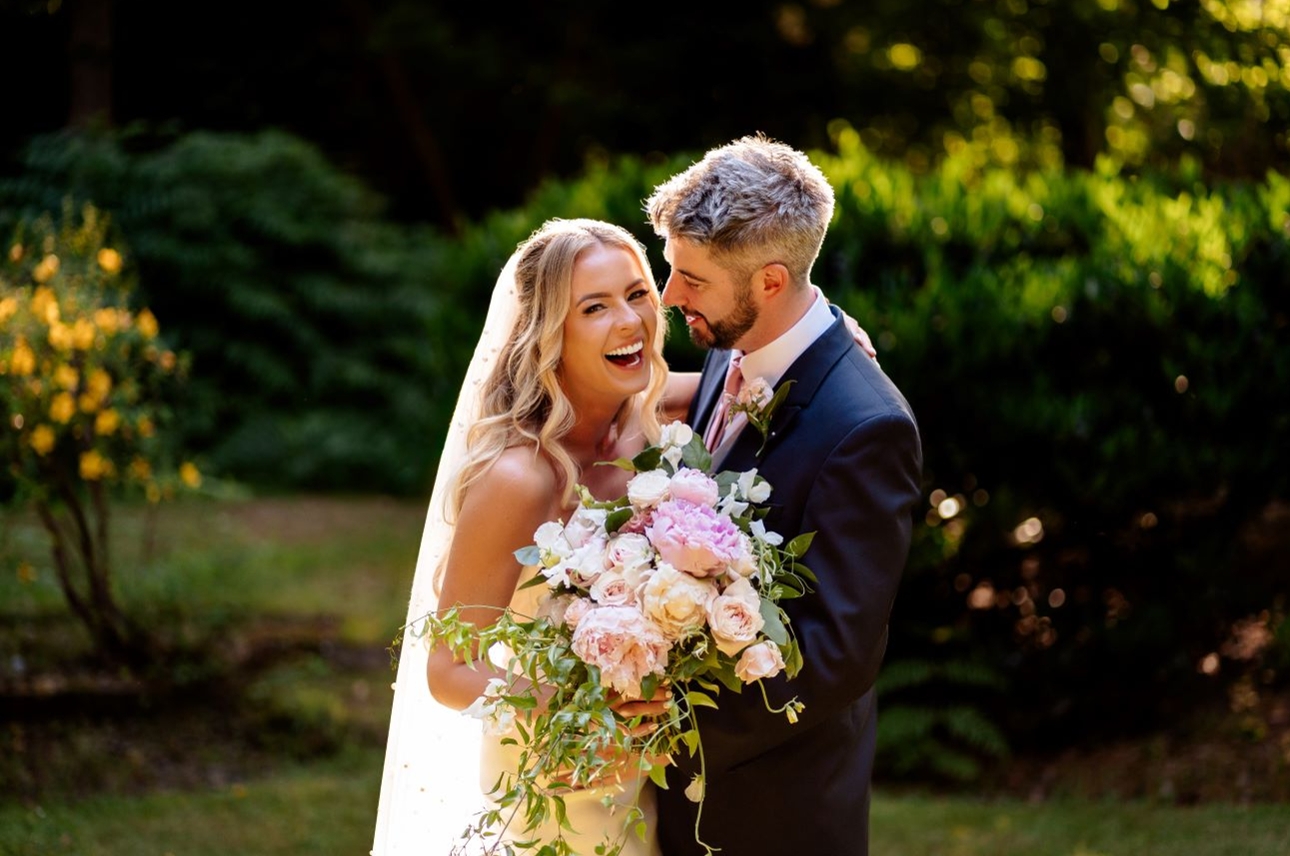 couple on wedding sunny. bridal laughing holding bouquet