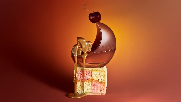 Ghost fragrance lifestyl shot, bottle with battenburg, cherry and fudge to mirror its fragrance
