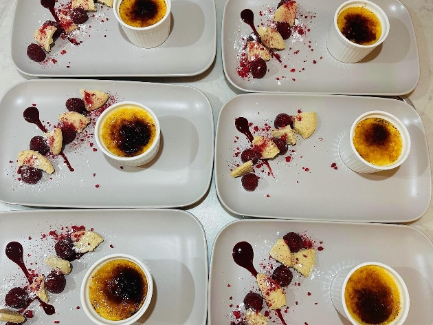 Plates of crème brûlée with fruit