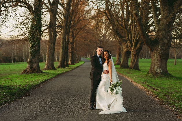 A bride and groom embracing surrounded by trees
