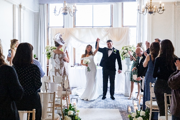 The Milner York, bride and groom raise their arms in celebration after wedding ceremony