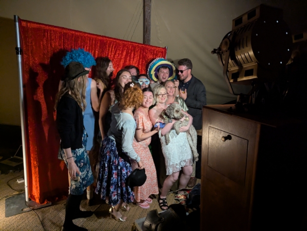wedding guests gathered around a vintage booth nineteen photo booth
